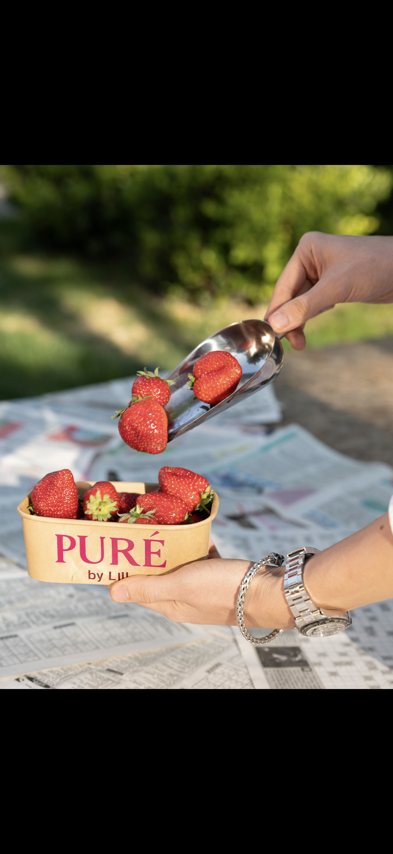 Hands holding PURÉ strawberry basket