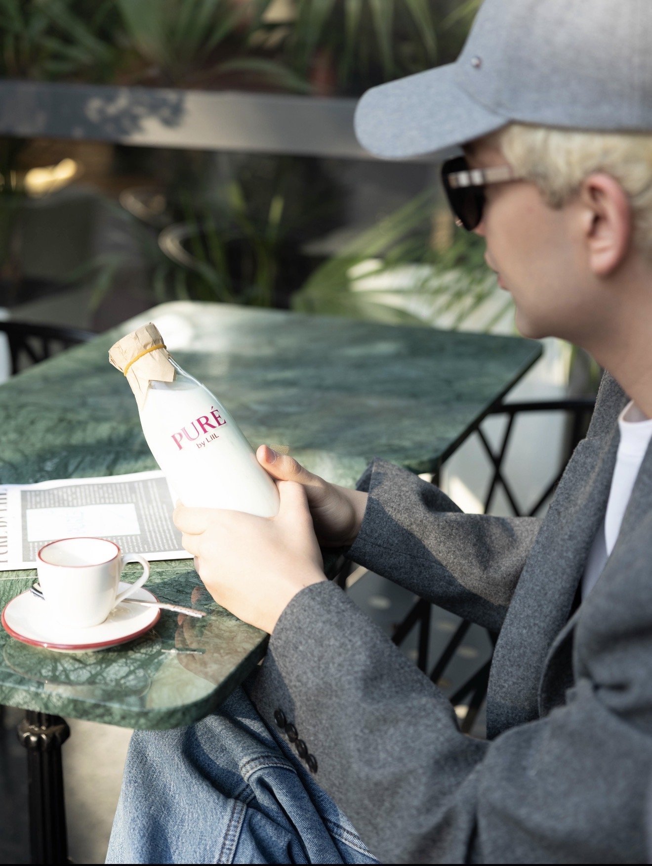 LiiL with PURÉ milk bottle at marble café table